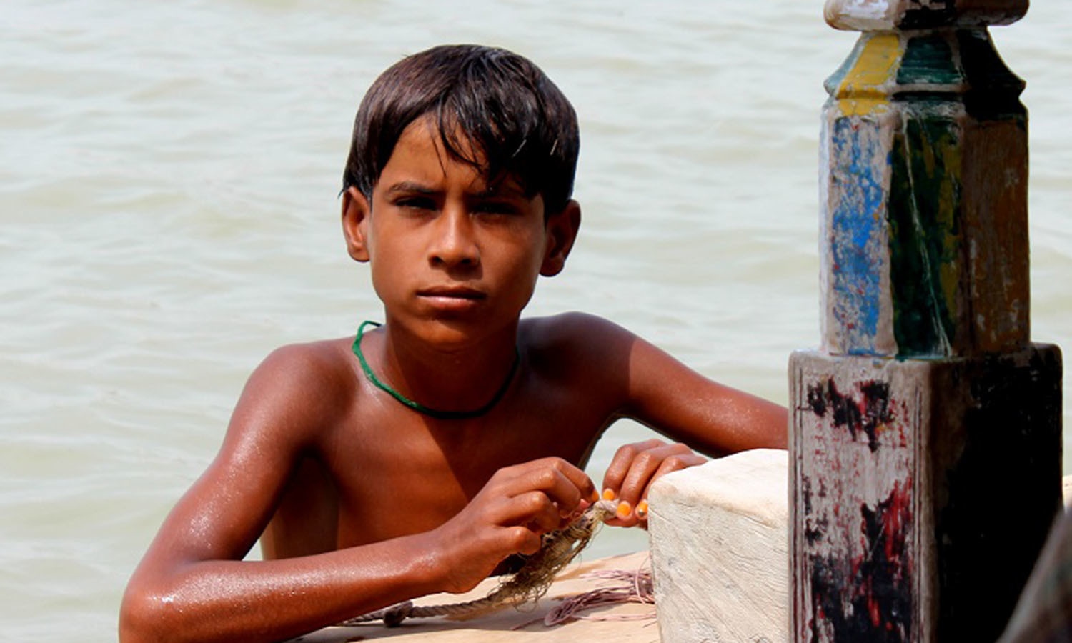 The children do not go to school and while away the time playing in the water or helping with house work.