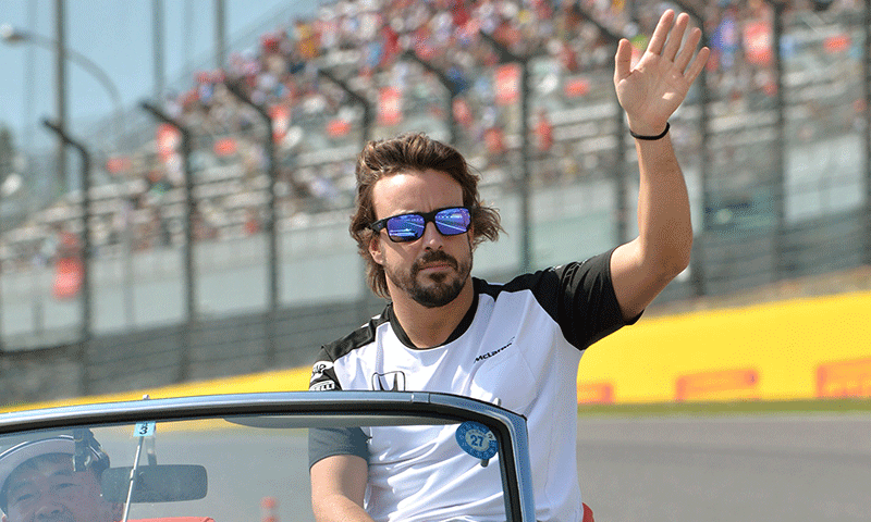 McLaren driver Fernando Alonso of Spain waves on a classic car during a drivers parade ahead of the Formula One Japanese Grand Prix at the Suzuka circuit on Sunday. — AFP
