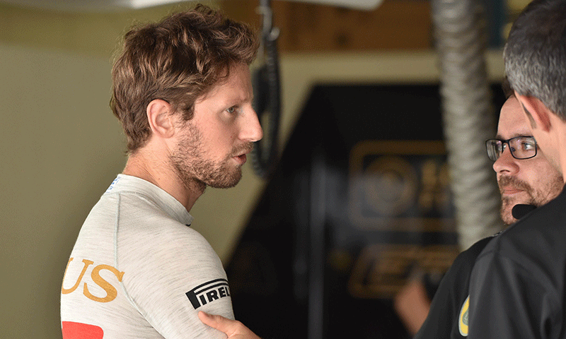 Lotus driver Romain Grosjean of France (L) talks with his teammates before the third practice session of the Formula One Japanese Grand Prix at the Suzuka circuit on Saturday. — AFP