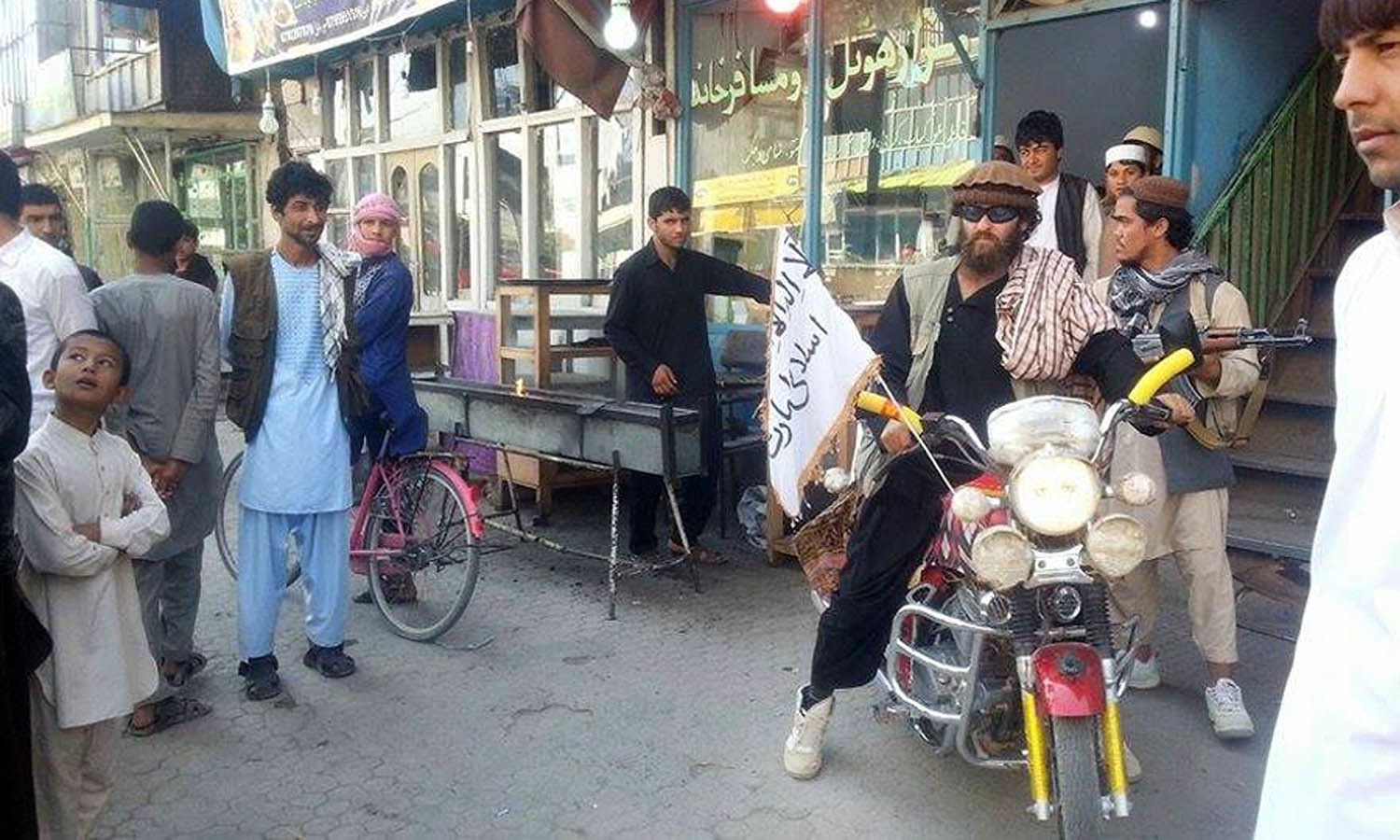 A Taliban fighter sits on a motor-cycle sporting a Taliban flag a day after the insurgents overran the strategic northern city of Kunduz. — AFP