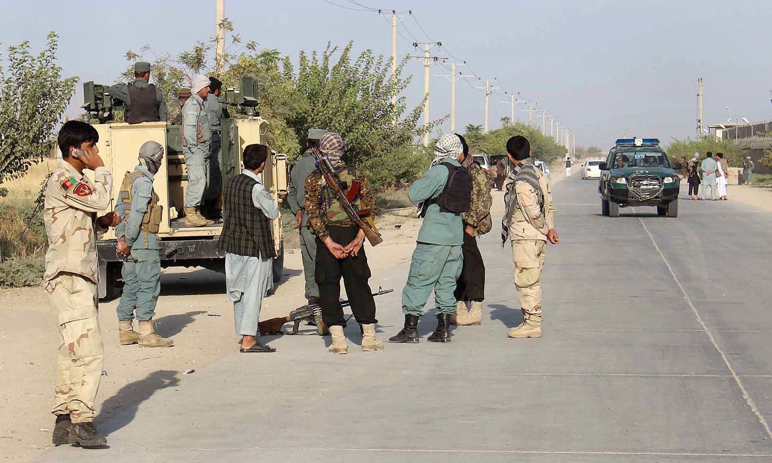 Afghan security forces gather at the roadside a day after Taliban insurgents overran the strategic northern city of Kunduz. — AFP