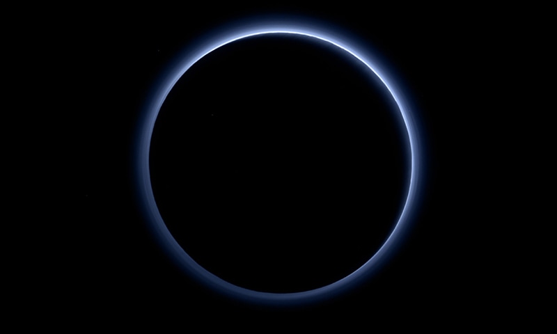 This image released by NASA on October 8, 2015, shows Pluto’s haze layer and its blue colour. ─ AFP