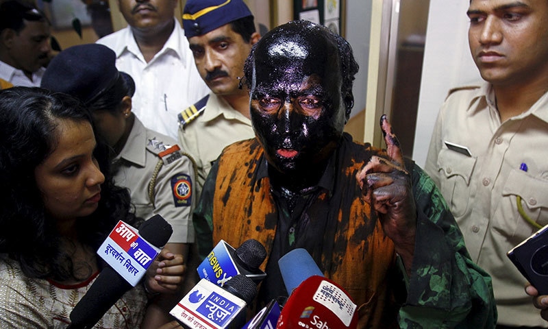 Sudheendra Kulkarni, chairman of the Observer Research Foundation Mumbai, with his face smeared with black ink, speaks to journalists in Mumbai ─ Reuters