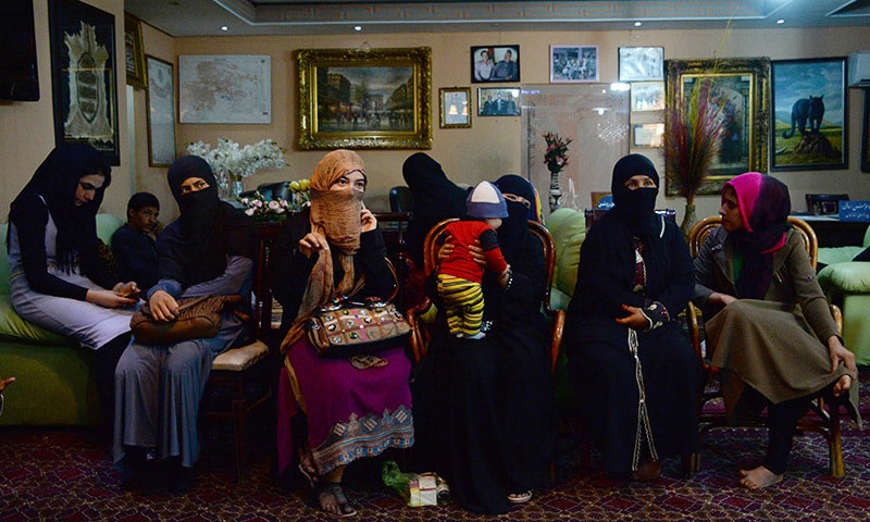 In this photograph taken on October 10, 2015,  young Afghan women, who have been displaced from the northern Afghan city of Kunduz during clashes between Afghan security forces and Taliban insurgents, speak as they gather waiting for temporary shelter donated by a businessman at a hotel in Kabul. —AFP