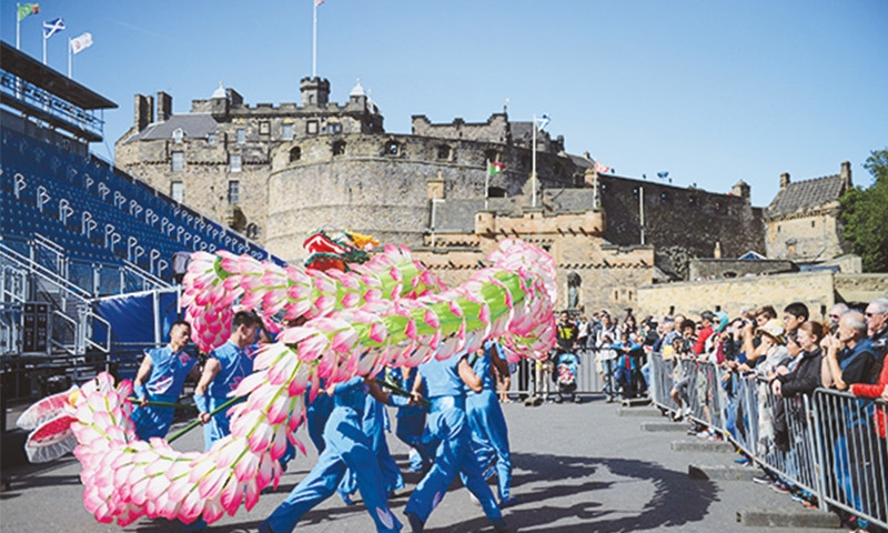 PERFORMERS from Changxing Lotus Dragon Dance Folklore Group stage a dragon dance on a plaza in Edinburgh.