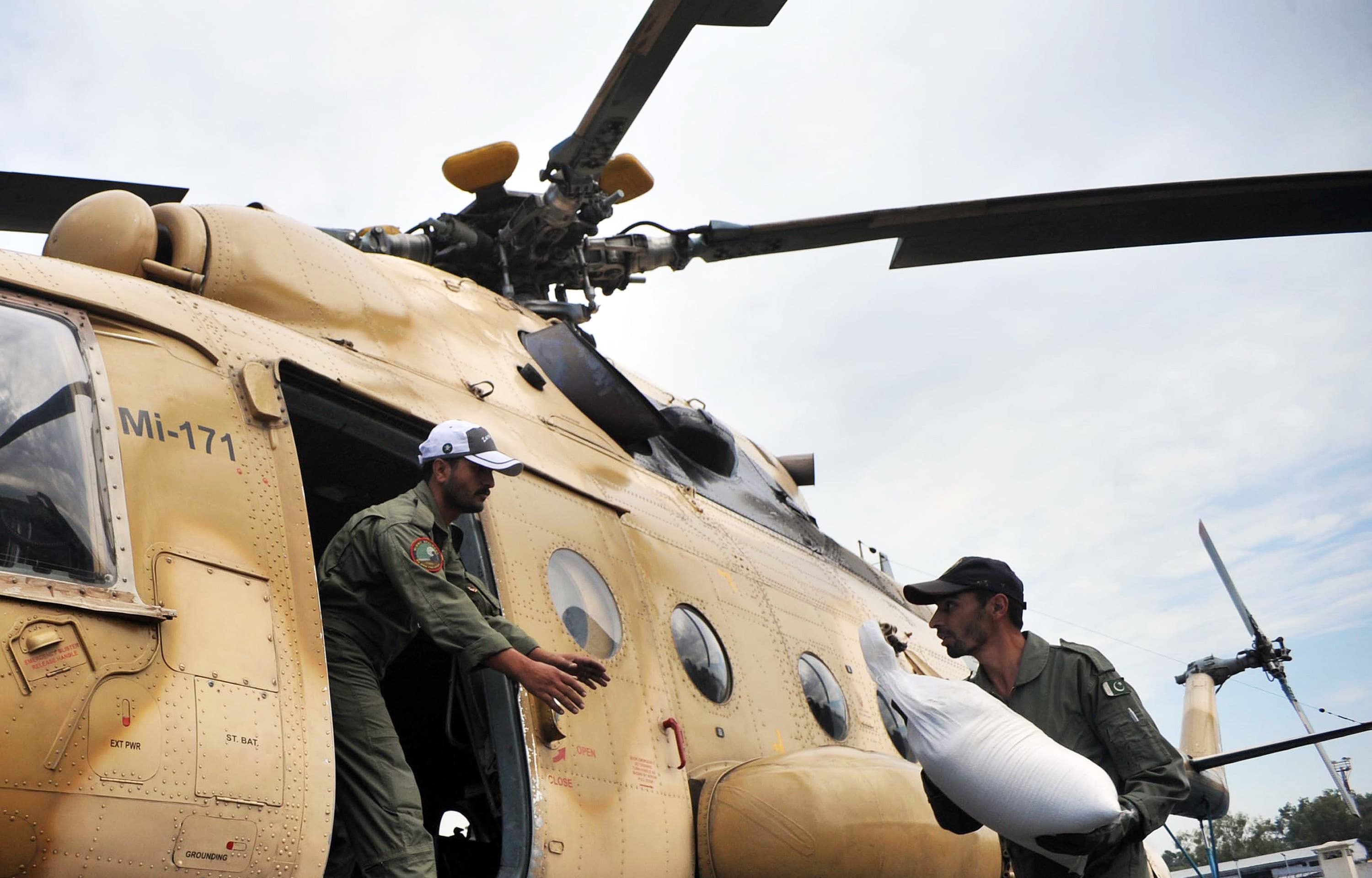 Pakistani soldiers load food bags for earthquake survivors into an army helicopter in Peshawar on October 27, 2015. —AFP