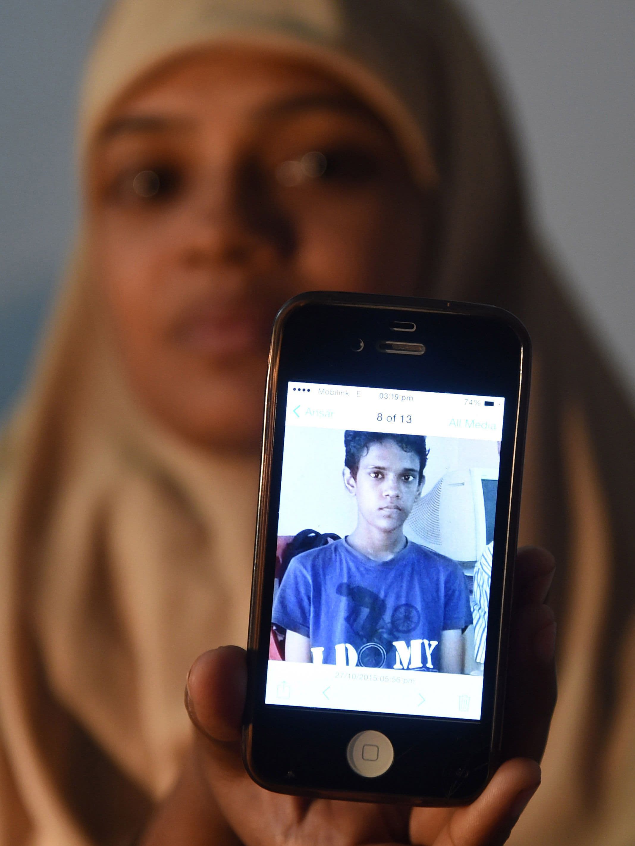 Razia Begum displays a picture of her son, Mohammad Ramazan during an interview in Karachi. —AFP