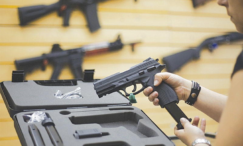 Sao Paulo (Brazil): A woman handles a pistol at a gun shop in Sao Caetano do Sul on Friday. Brazil has one of the highest murder toll on the planet.—AFP