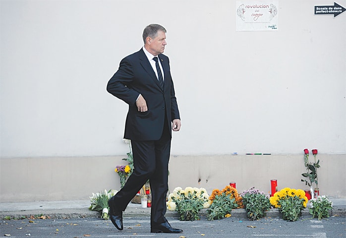 Bucharest: Romanian President Klaus Iohannis prepares to light a candle outside the nightclub where a fire broke out on Friday.&mdash;Reuters