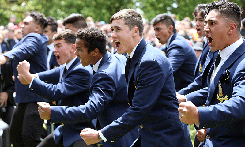 Students perform a Hakka for New Zealand's All Blacks after their arrival at a parade and official welcome for the team in Auckland. — AFP