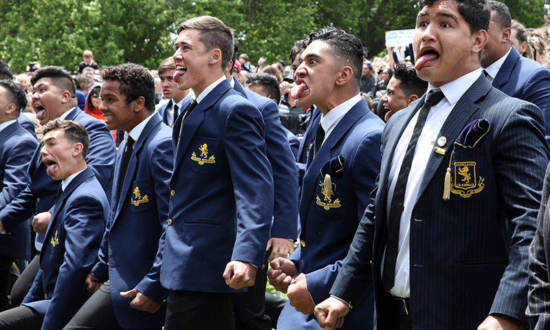 Students perform a Hakka for New Zealand's All Blacks after their arrival at a parade and official welcome for the team in Auckland. — AFP