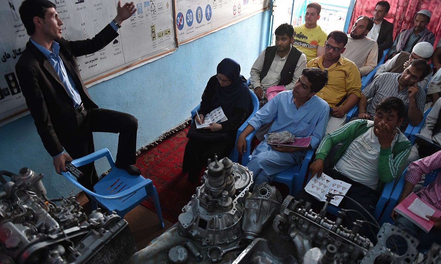 In this photograph taken on September 4, 2015, an Afghan instructor (L) teaches during a lesson at the Haidari Driving School in Kabul.  — AFP