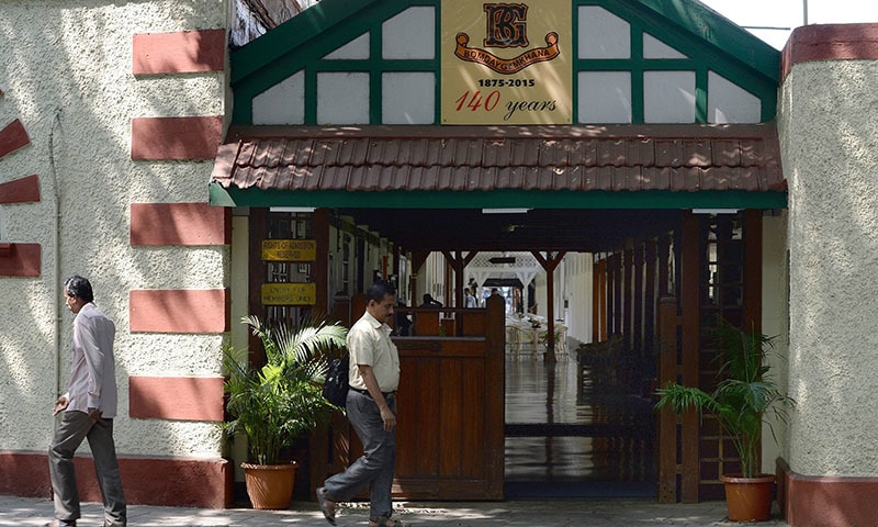 Indian pedestrians walk past the entrance to The Bombay Gymkhana Club in Mumbai. &mdash; AFP