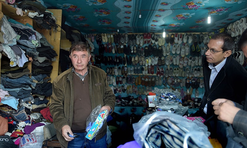 In this photograph taken on September 29, 2015, a local shopkeeper interacts with customers in Sost, the border town of the Hunza valley. — AFP