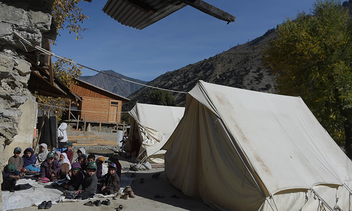 Children attend class outside their school, where tents are set up to accommodate students and teachers. ─ AFP