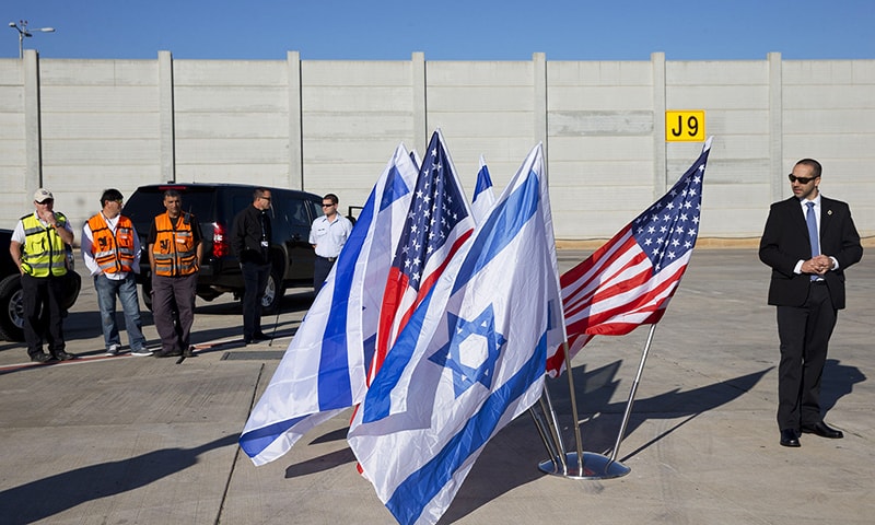 Security personnel wait by US and Israeli flags as US Secretary of State John Kerry arrives in the Israeli coastal city of Tel Aviv on November 24, 2015. —AFP