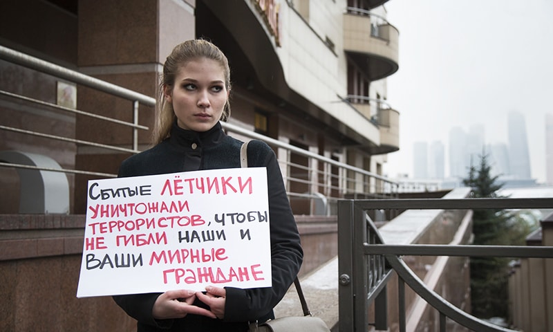 A woman holds a poster as she pickets the Turkish Embassy in Moscow, Russia, Tuesday, Nov. 24, 2015. —AP