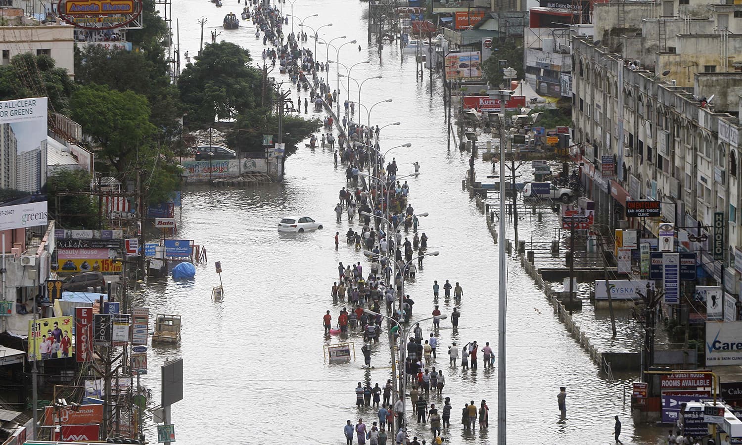 People walk through a flooded street in Chennai, India, Thursday, Dec. 3, 2015. — AP