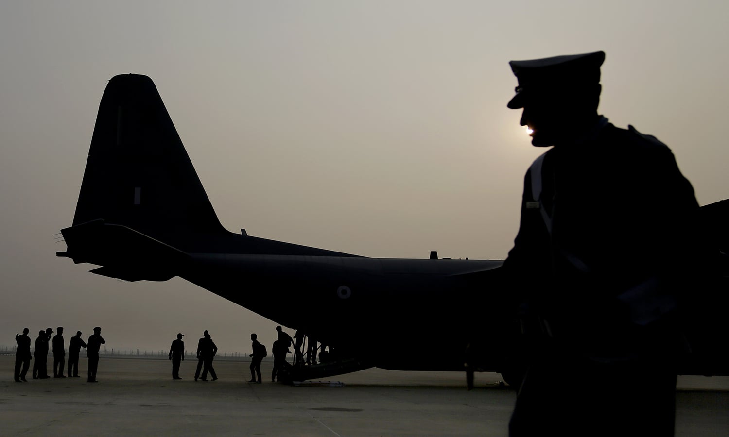 An Indian Air Force personnel is silhouetted as people who were stranded in Chennai due to floods deplane in New Delhi after being evacuated by the air force Thursday, Dec. 3, 2015. — AP