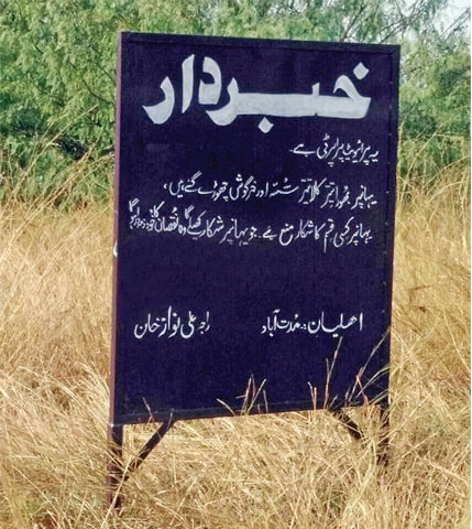 An illegal signboard declaring the area as a private game reserve. According to officials, however, there is no private game reserve in Chakwal district. — Dawn