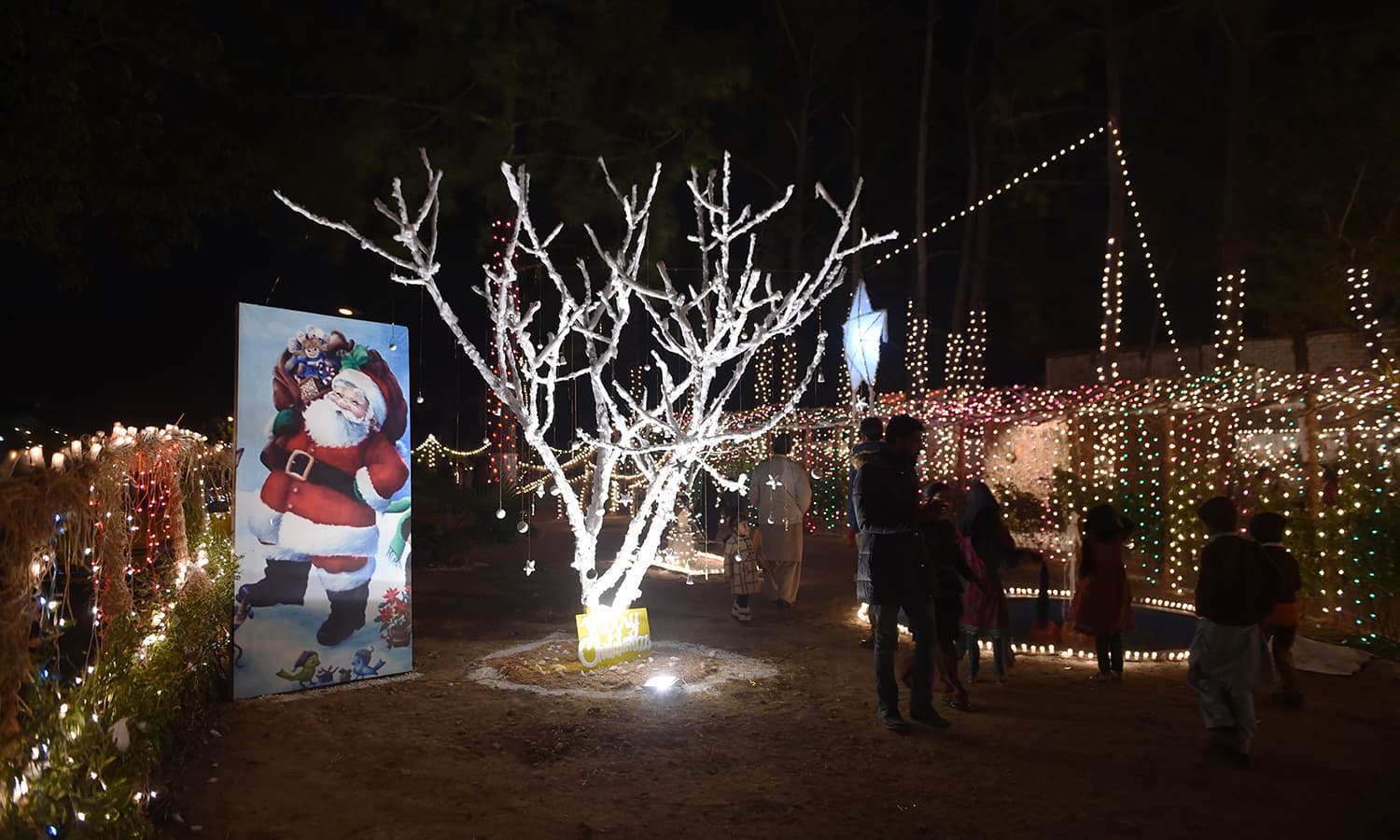 People walk past Christmas decorations displayed in Islamabad. &mdash;AFP