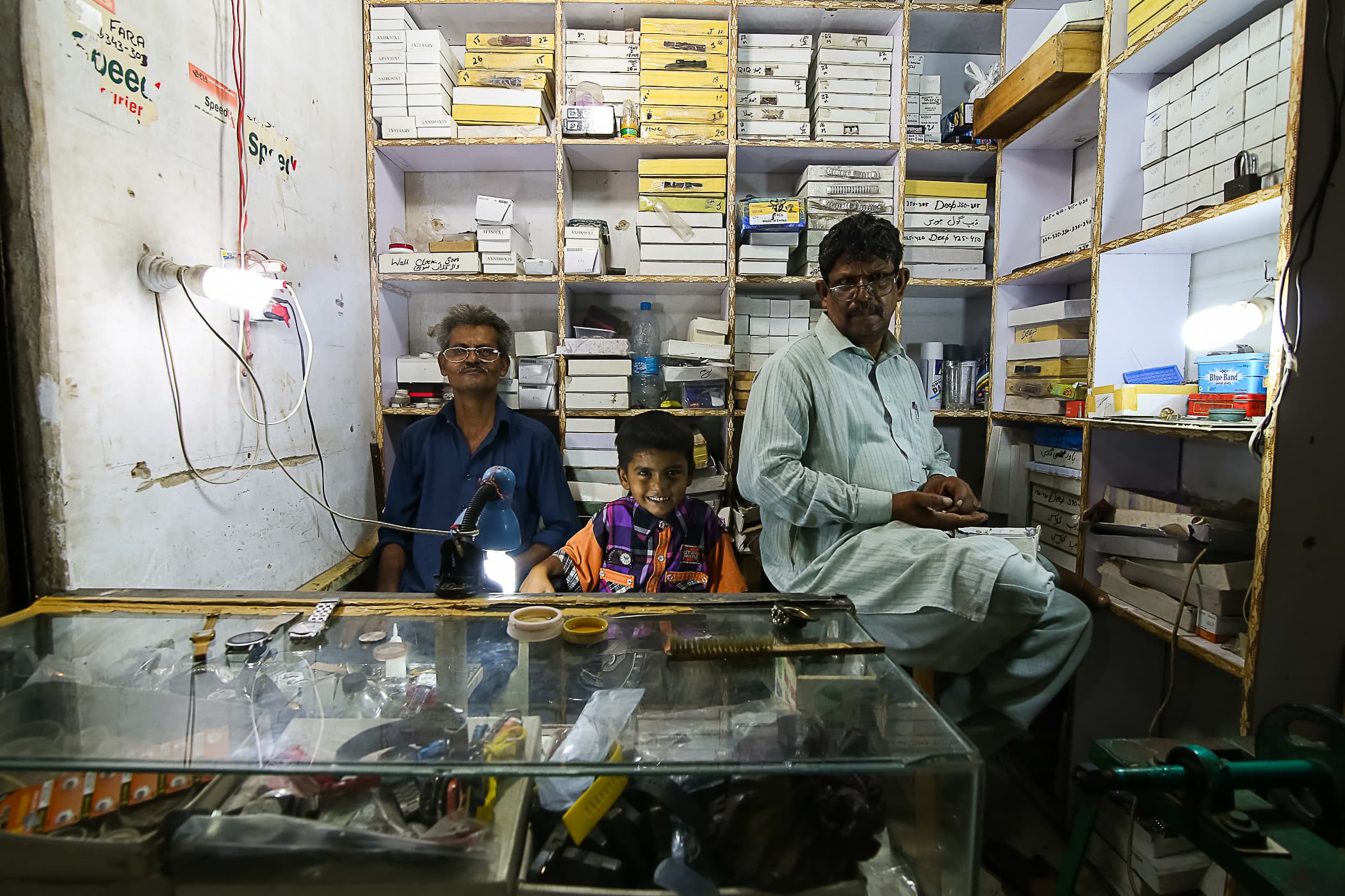 Shahid, his son and Mazhar at their workshop at Karim Centre, Bolton Market.