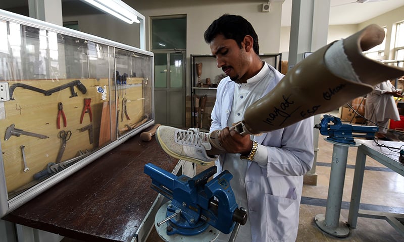 A technician prepares artificial limbs at the Pakistan Institute of Prosthetic and Orthotic Sciences (PIPOS) in Peshawar. — AFP