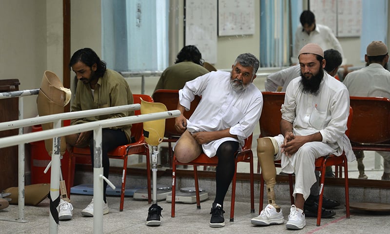 Improvised explosive device (IED) victims sit at the Pakistan Institute of Prosthetic and Orthotic Sciences (PIPOS) in Peshawar. — AFP