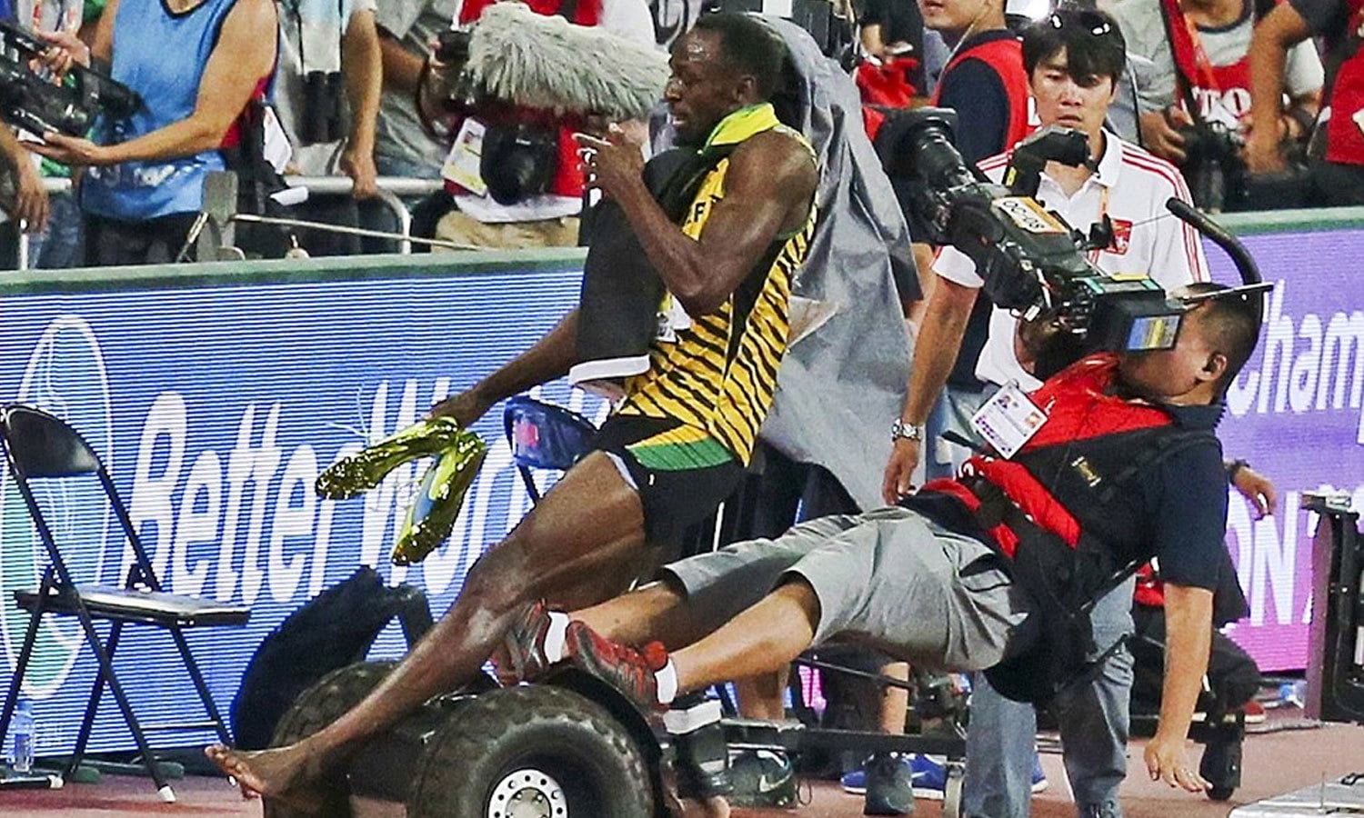 جمیکن ایتھلیٹ یوسین بولٹ چین کے دارالحکومت بیجنگ میں منعقدہ ورلڈ چمپیئن شپ اگست 2015کے 200 میٹر دوڑ میں کامیابی کے بعد کیمرہ مین کے اوپر گر پڑے تھے۔ فوٹو: رائٹرز