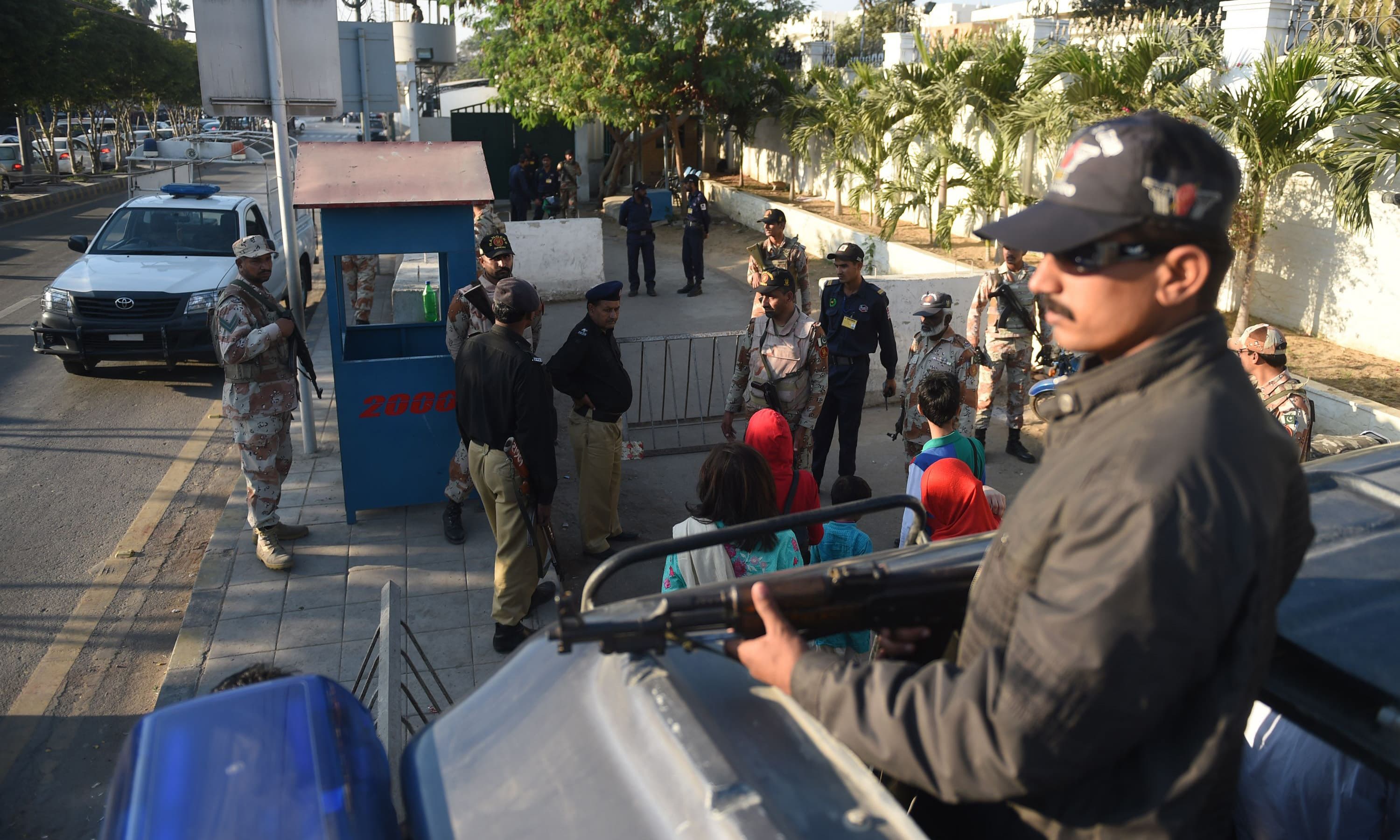 Security officials stand guard in front of the Saudi Arabia embassy during the protest in Karachi. —AFP