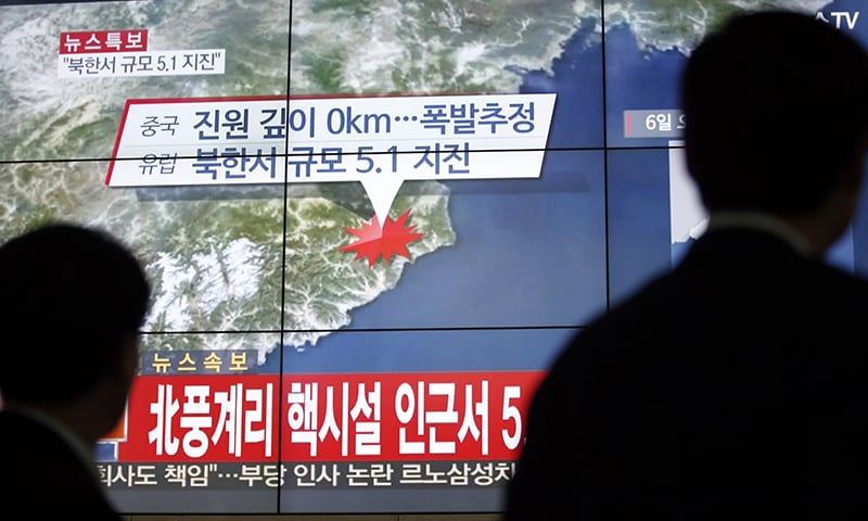 People walk by a screen showing the news reporting about an earthquake near North Korea's nuclear facility, in Seoul, South Korea. ─ AP