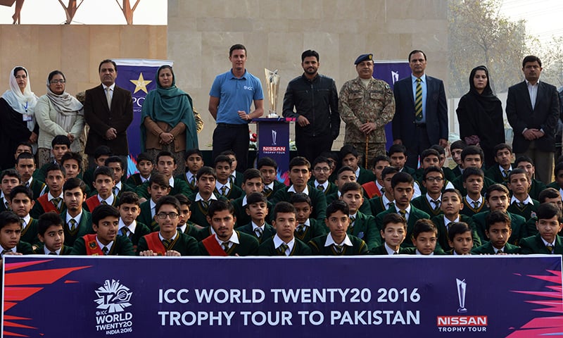 Pakistan ODI captain Azhar Ali stands alongside the ICC 2016 World T20 trophy as he poses for a photograph with students from the Army Public School (APS) in Peshawar on January 11, 2016. &mdash; AFP