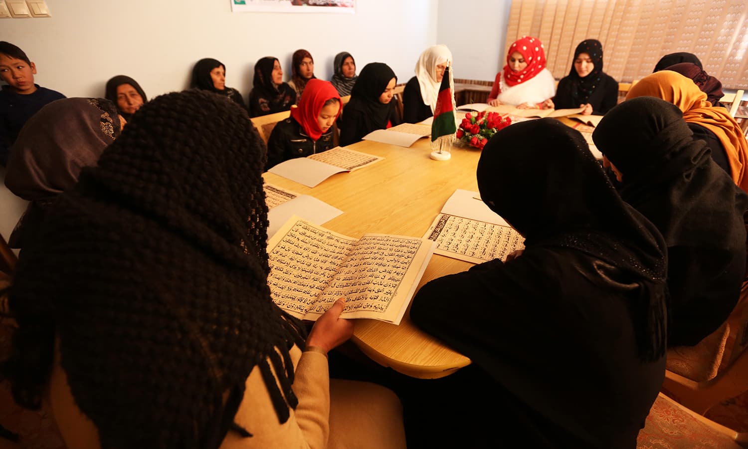 Afghan women read the Holy Quran at the office of Afghanistan General association of public servants in Kabul. - AP