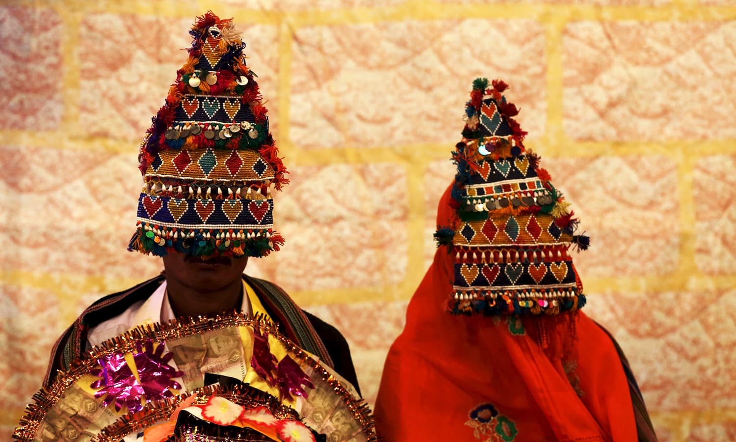 A bride and groom wearing traditional handmade garlands wait for their wedding to start during a mass marriage ceremony in Karachi organised by the Pakistan Hindu Council. ─ Reuters