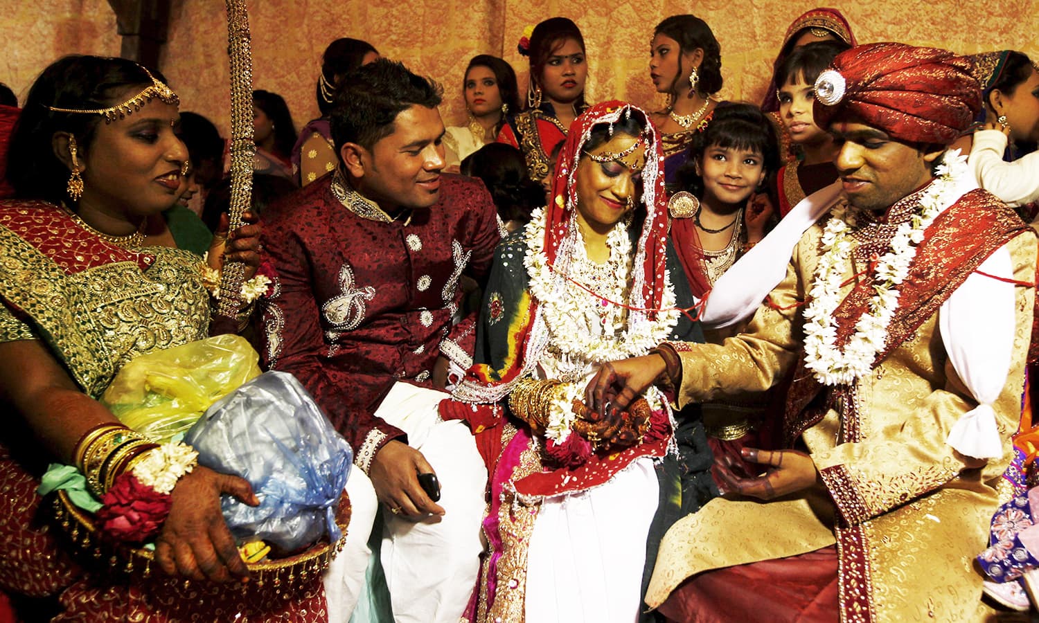 A bride and groom couple go through a ritual during a marriage ceremony. ─ Reuters