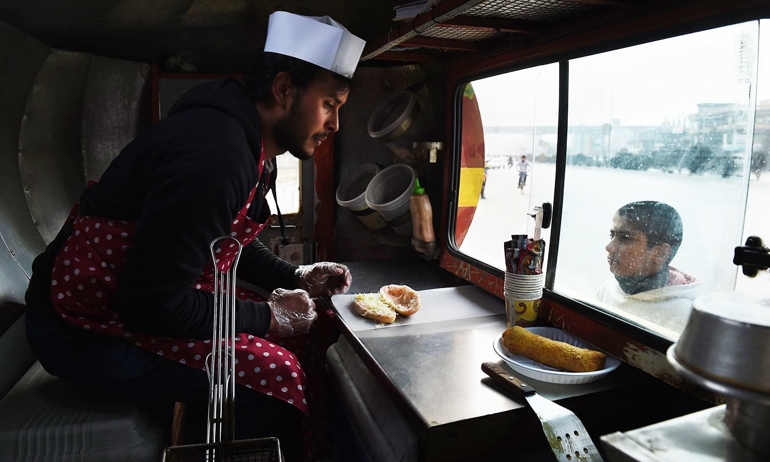 An Afghan customer buys a burger from a Lazeez food truck in Kabul.&mdash;AFP
