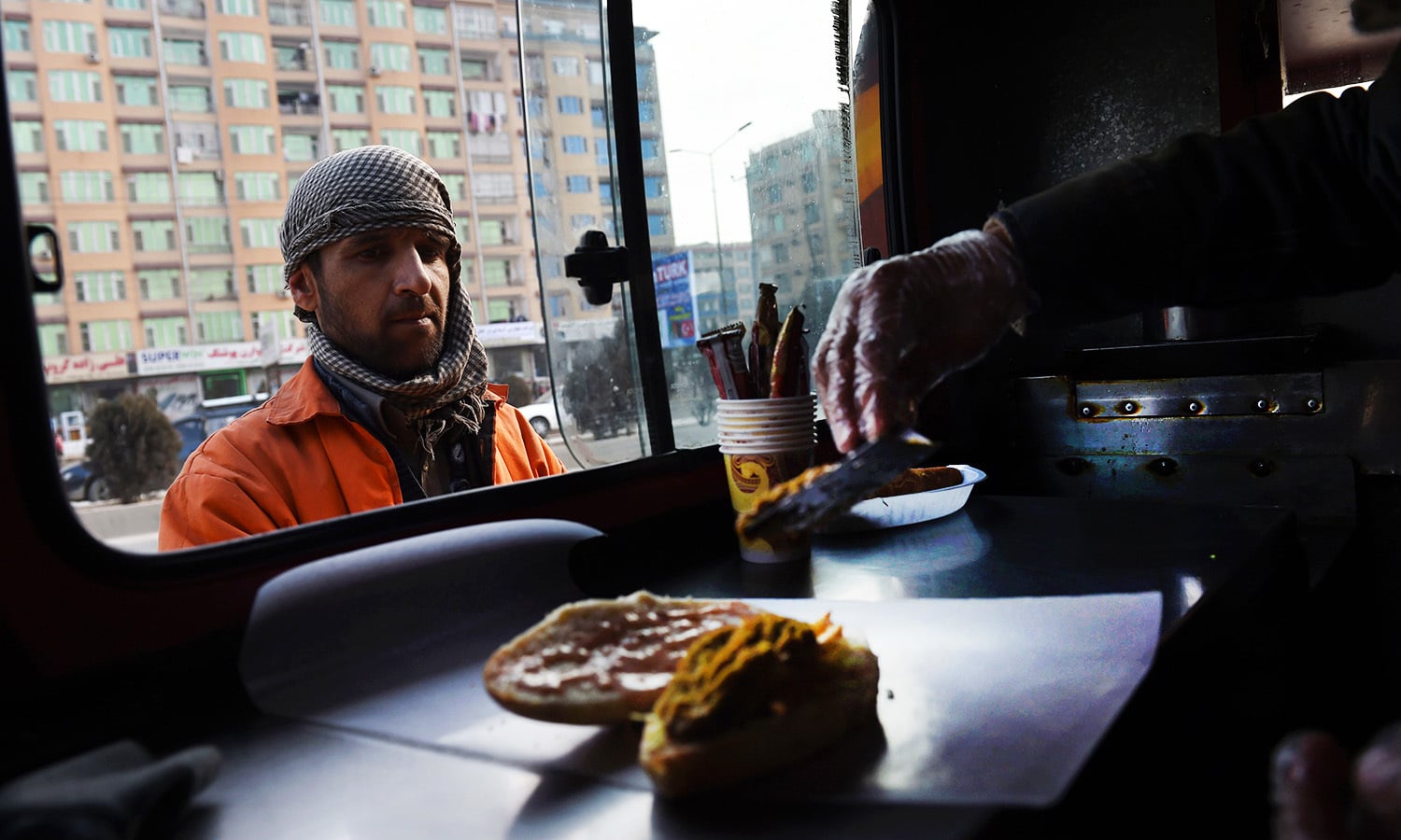 An Afghan customer buys a burger from a Lazeez food truck in Kabul in this Dec 27, 2015 photo.&mdash;AFP