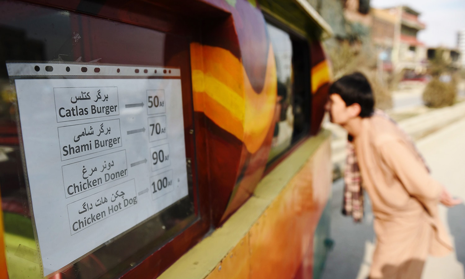 An Afghan customer buying a burger from a Lazeez food truck in Kabul in this Dec 27, 2015 photo.&mdash;AFP