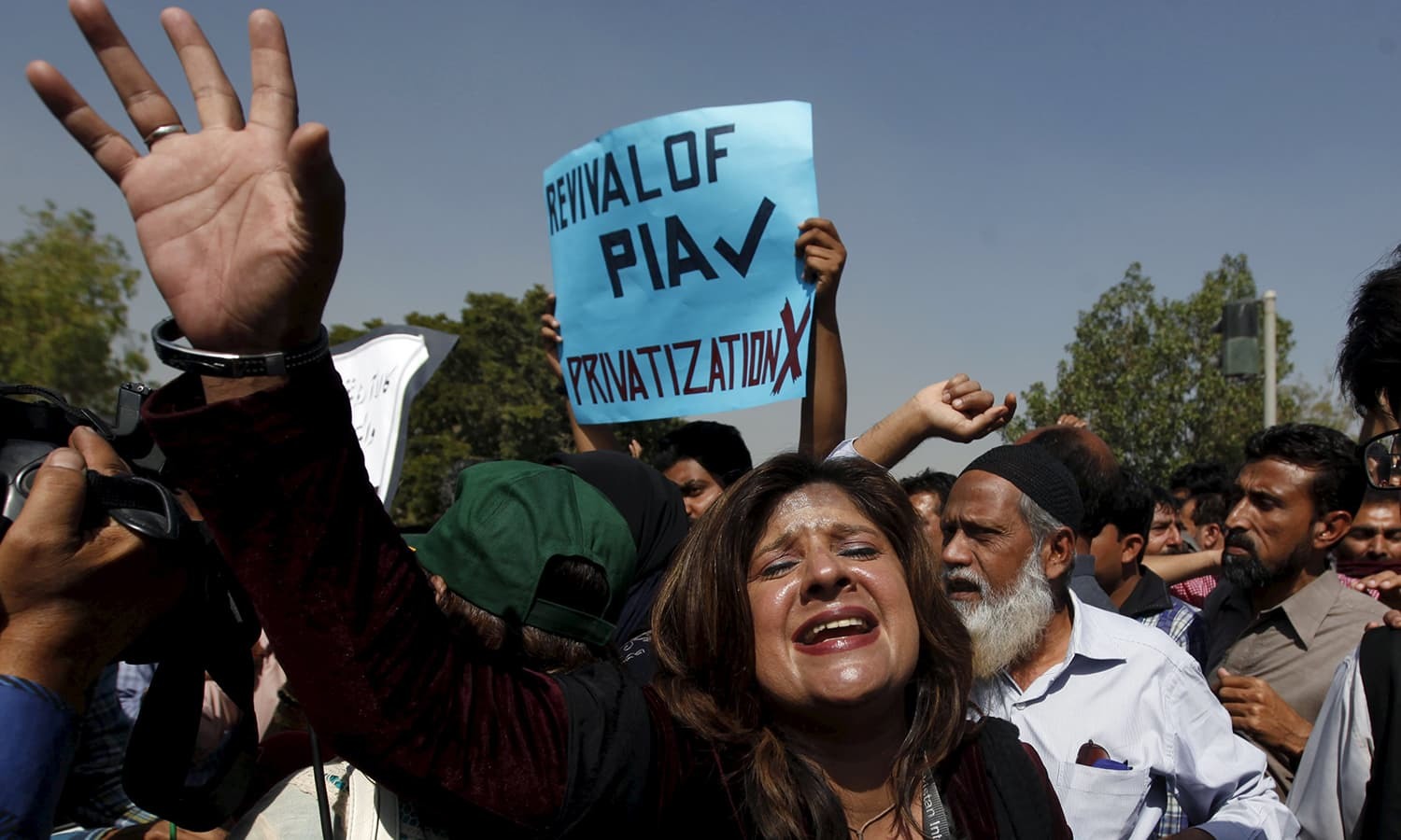 PIA Employees chant slogans as they march towards the Jinnah International Airport. ─ Reuters