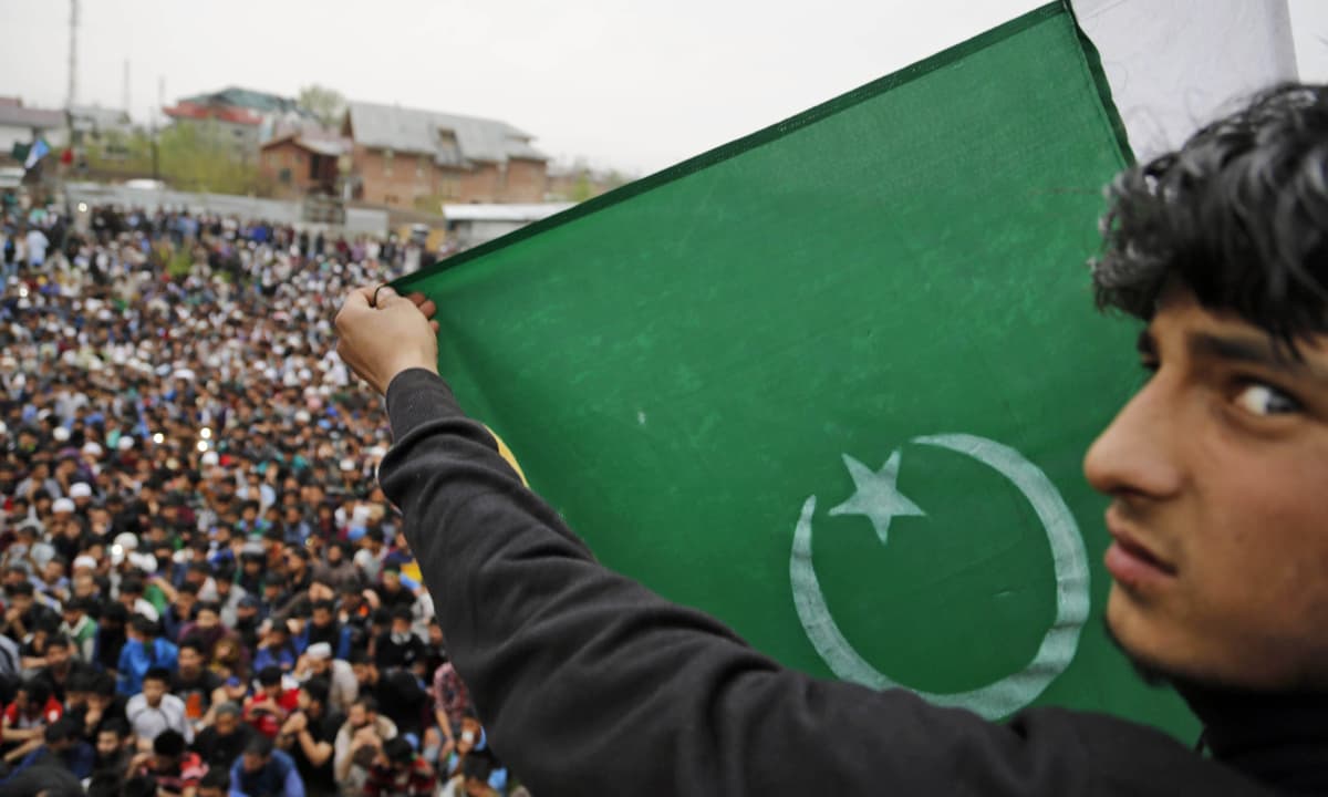 A supporter of senior separatist leader, Syed Ali Shah Geelani, carries a Pakistani national flag during a rally in Srinagar | Mukhtar Khan, AP