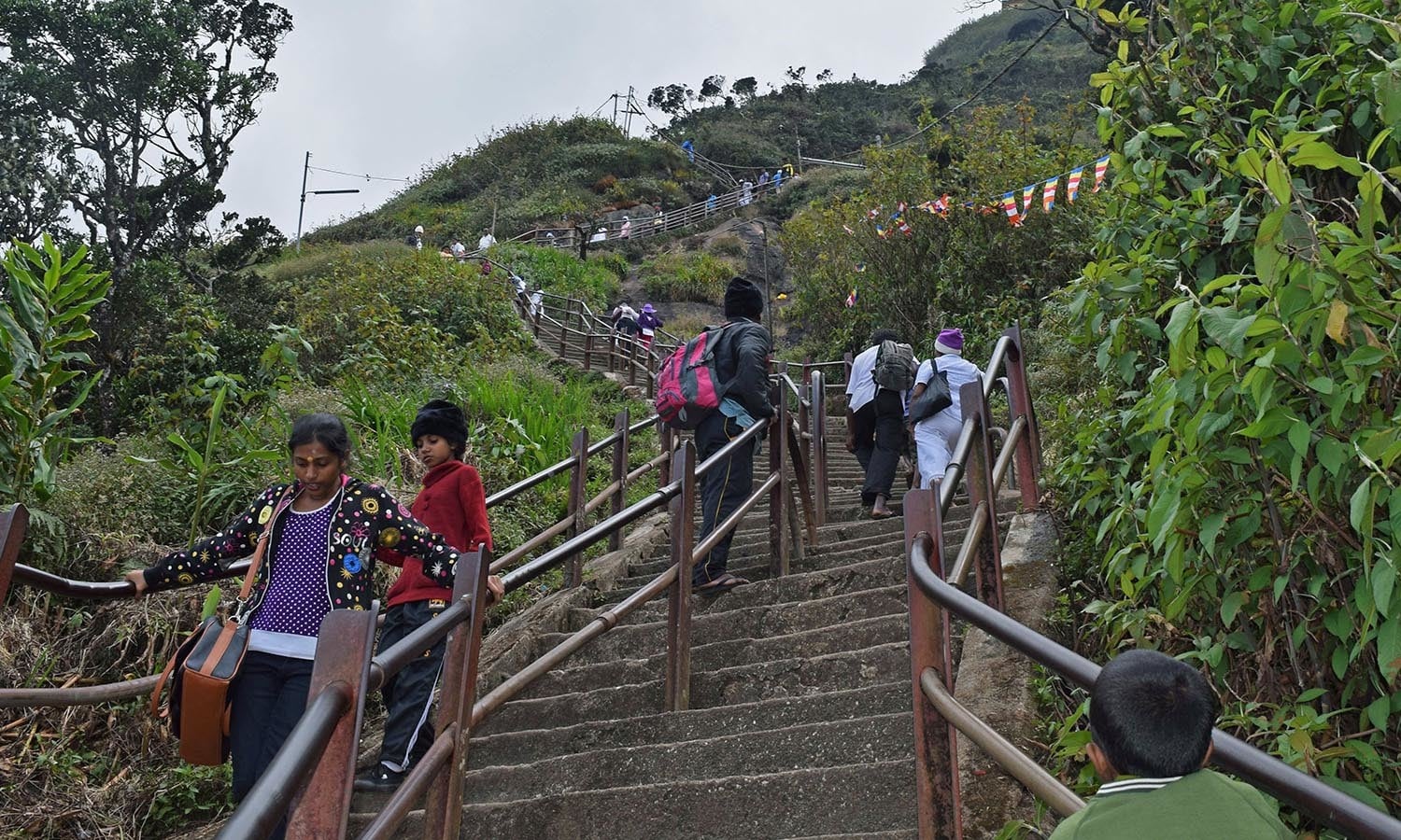 Some visitors walk up while others rest on steps to Adam's Peak. ─Photo by the author