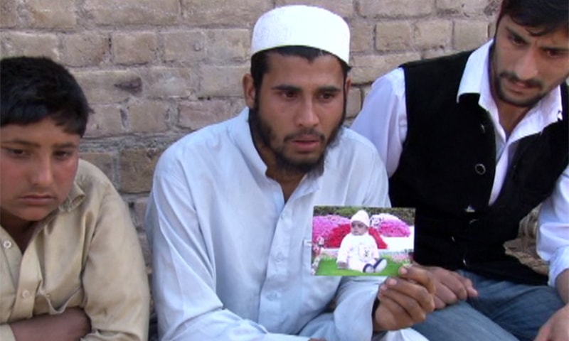 Qari Khalid holds a photograph of his deceased son Huzaifa. ─ Photo by author