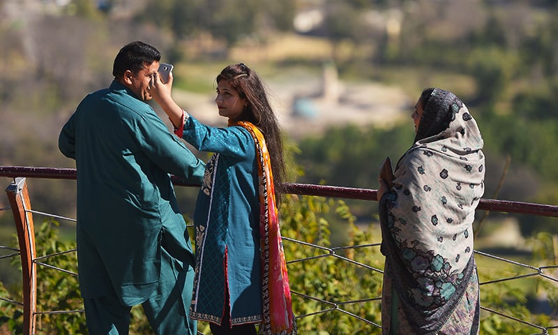 A young Pakistani woman takes a 'selfie' at a Margalla Hills viewpoint in Islamabad. ─ AFP