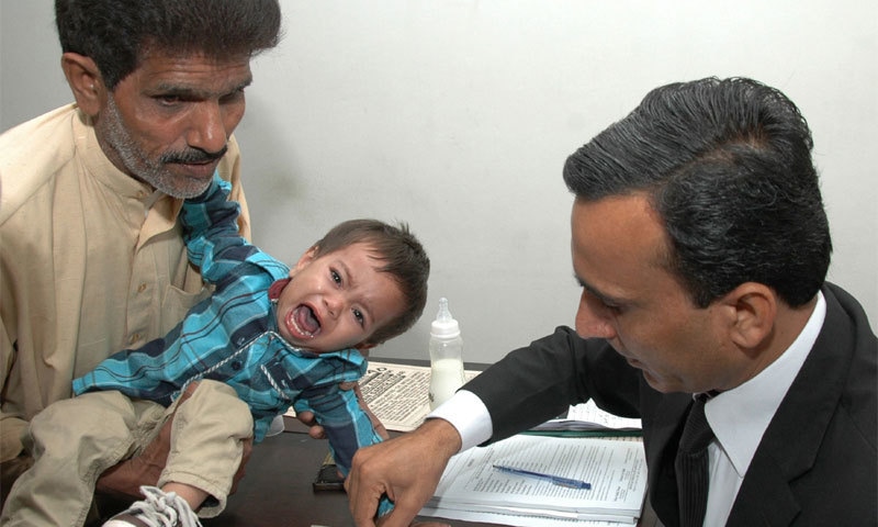 A lawyer taking the thumb impression of nine-month-old Musa on a bail bond. &mdash;AFP.