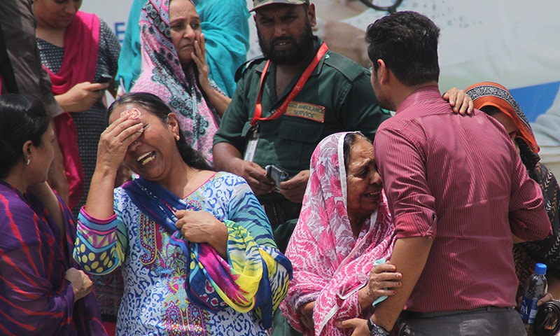 In this Wednesday, May 13, 2015 file photo, people mourn the deaths of their family members, gunned down on a bus in what was the Islamic State group's first appearance in Pakistan. ─AP