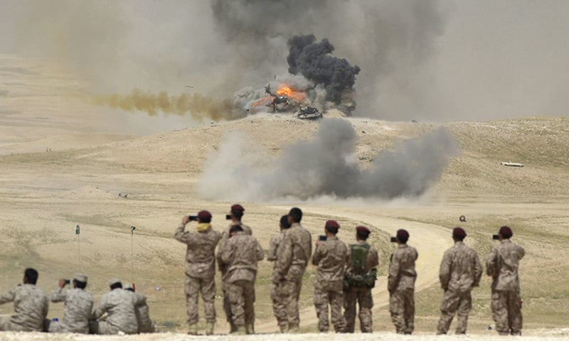 Soldiers take pictures as flame and smoke are seen following air bombardments during the Northern Thunder exercises, in Hafr Al-Batin.─Reuters
