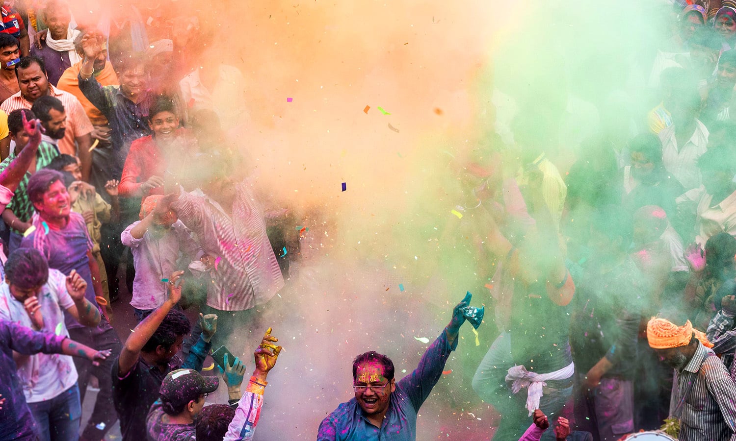 Indian villagers are covered in coloured powders during the Holi festival. ─ AFP