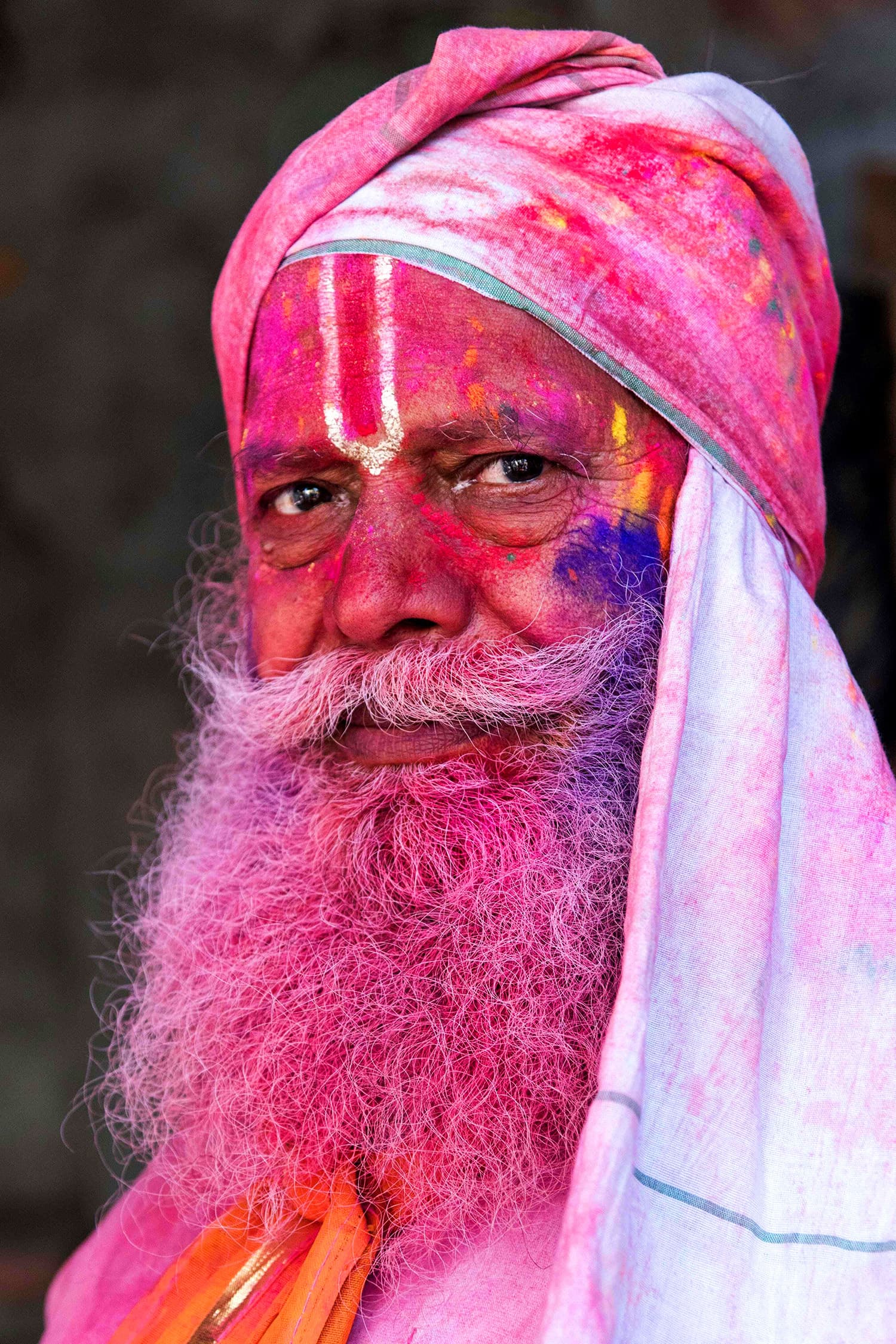 An Indian villager is smeared with colour powder during the Holi festival at the Radha Rani temple in Barsana. ─ AFP