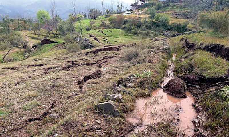 People stand near a collapsed house in Beer Garan in Murree’s Sehrbagla union council. The other picture is of a swept away field in Ghoe village. — Photos by the writer