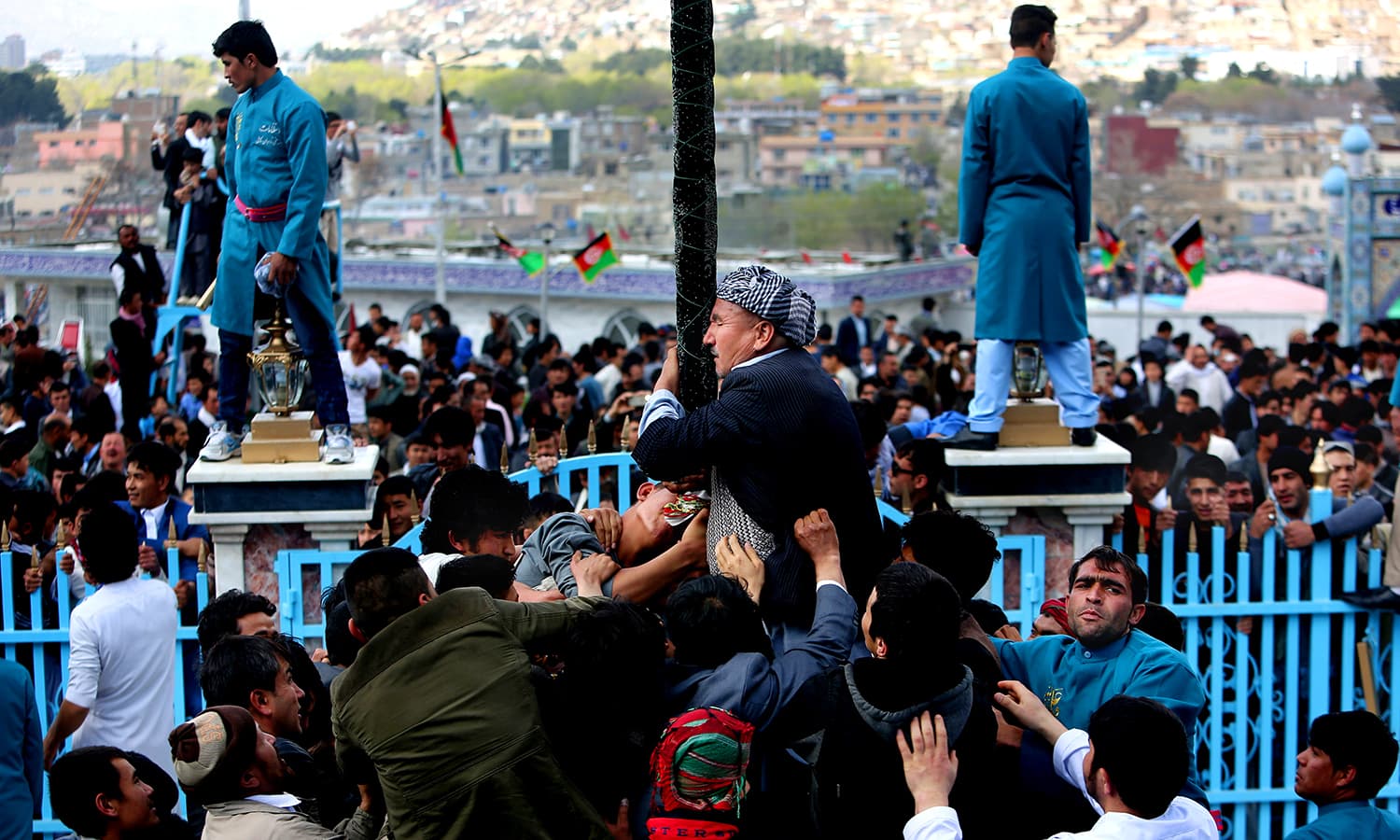 Afghan men kiss the holy mace for blessings during Nowruz. ─ AP